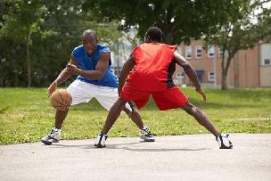Two men playing basketball for exercise